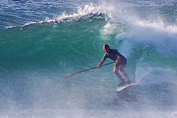 Zack shredding a wave on a SUP